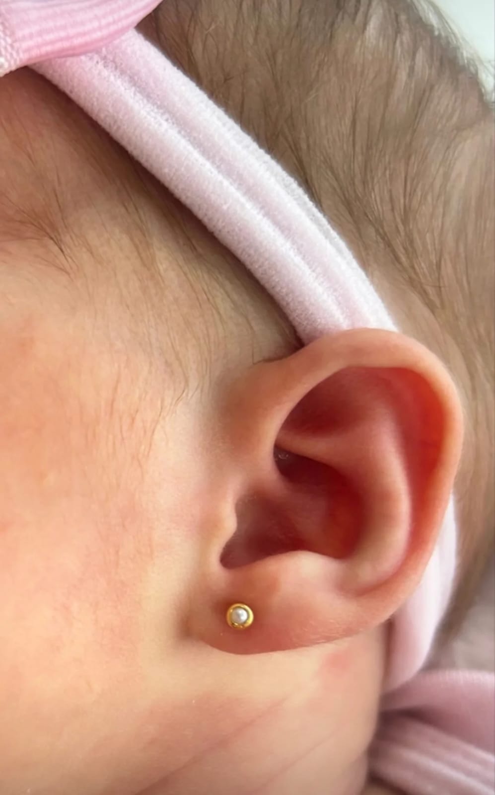 Piercing de pérola em bebê recém-nascida